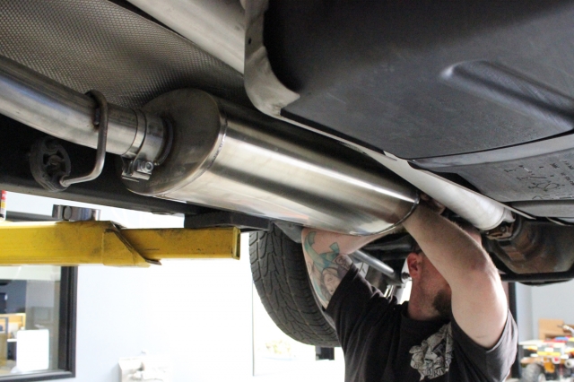 Dean checks the spacing between the muffler and crossmember.