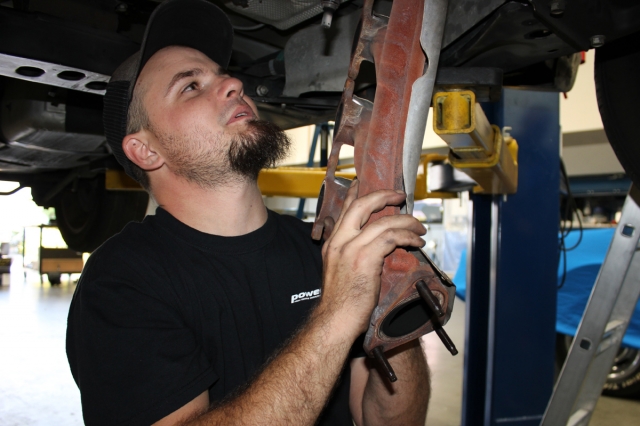 Dean grabs the free-hanging left-side exhaust manifold prior to its complete removal.