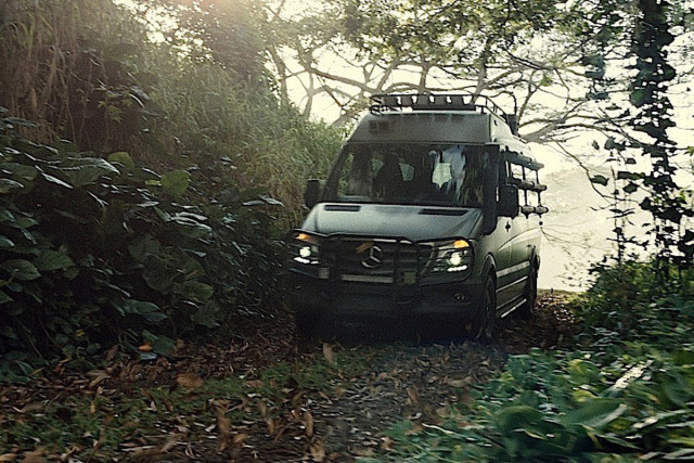 Mercedes-Benz Sprinter driving through the Jurassic World jungle.