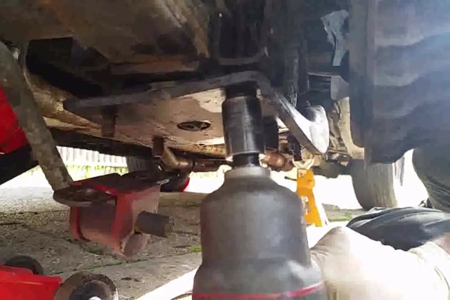 There are four nuts that secure the lower plate to the axle that need to be removed. For safety, you might want to place a jack under the leaf spring to keep it from jumping down. 