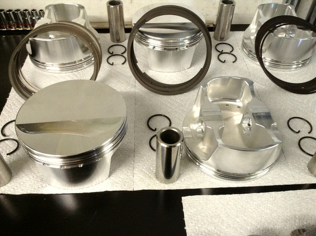 Seen here are the crowns and underside of the BLS1010 CP Pistons along with the rings, chro-moly wrist pins and round wire pin locks. The pistons are manufactured in the USA from 2618 alloy for strength and durability using a finite element analysis designed forging featuring dual forced pin oiling and are balanced to plus or minus 1 gram.