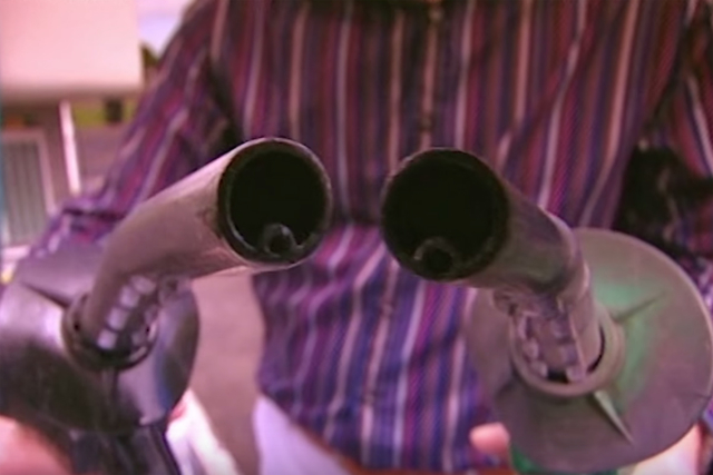 Host Jon Bentley holds up the gasoline (left) and diesel (right) fuel dispensers to show how easy it is to confuse them.