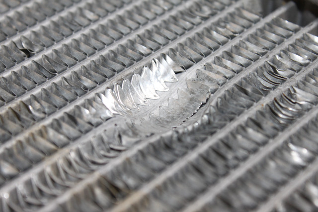 An example of bent fins on a radiator. While some bent fins are to be expected from normal wear and tear and handling, any area more than 3-4 in diameter presents a significant cause for replacement of the radiator.