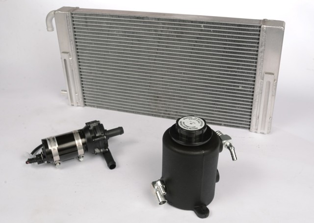 Kenne Bell superchargers use water-to-air charge cooling so the usual two heat exchangers, pump and reservoir are required—plus a few more nuts and bolts we elected not to clutter the photo with. This radiator mounts behind the bumper; the other heat exchanger is in the intake manifold.