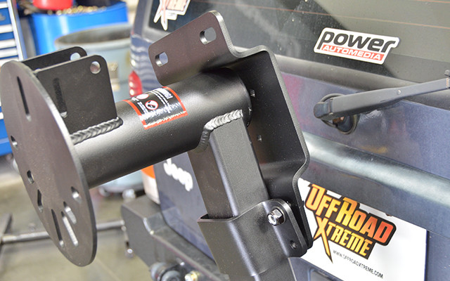 The Rotopax/Hi-Lift bracket clamps to the vertical tube of the swing arm. Position the bracket so the top portion rests on the top tube. 