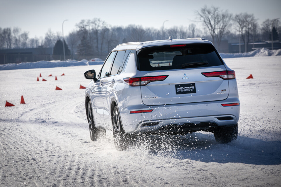 White 2024 Mitsubishi Outlander PHEV and its S-AWC system tested in a slalom course.