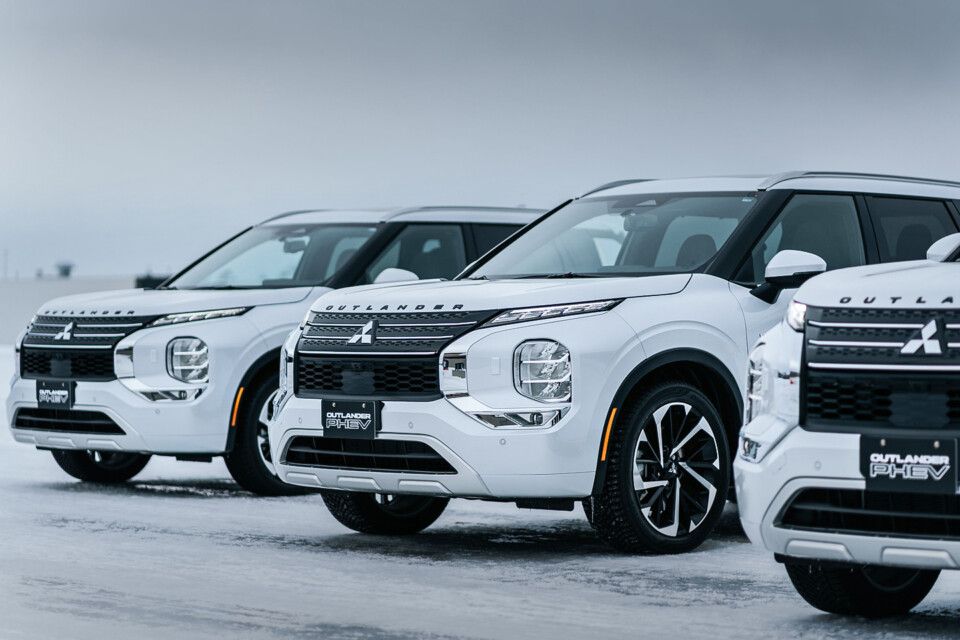 Line-up of 2024 white Mitsubishi Outlander PHEV SUVs. 