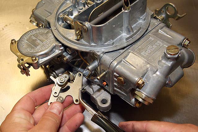 A small retaining pin keeps the choke rod from falling out of the backing plate's hole. When you remove the pin, set it aside because it will be reused.