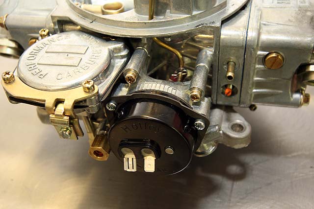 A metal retaining ring holds the choke cap to the choke body. It uses spring pressure to hold the cap in place, so make sure the ring is installed so that it bows outward from the choke cap as you can see here.